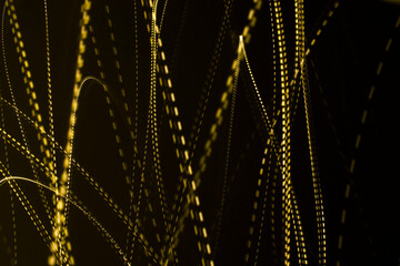 Yellow light streaks on a black background (long exposure).