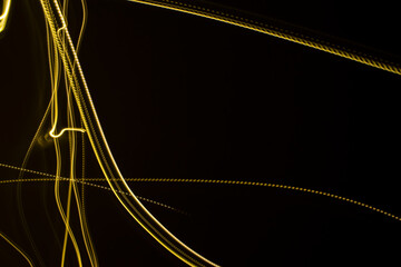 Yellow light streaks on a black background (long exposure).