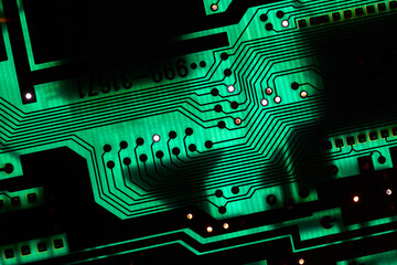 Circuit board electronics macro glowing in green light, technology background © Gudellaphoto