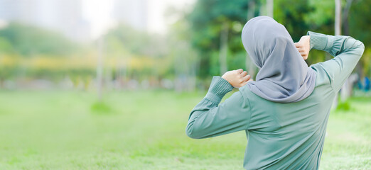 Back of Islamic woman morning exercises in the garden.