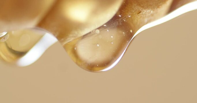 Drops of fresh honey are slowly dripping. 