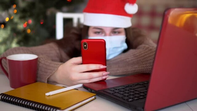 female studentin santa hat makes conference video call on laptop computer talks with web tutor, online teacher in remote webcam chat on screen. Distance education class concept.