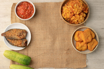 Indonesian Popular Daily Side Dish, Salted Fish, Sambal, Fried Tofu,  Cucumber, and Corn Fritter. This Dish Usually find in Warung Nasi tegal (warteg)
