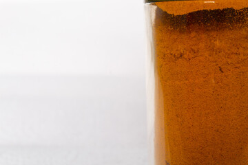 close up of kitchen spices in a glass container on a white background