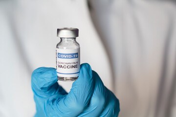 Doctor holding laboratory injection vial with Coronavirus or Covid-19 vaccine