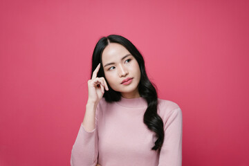 Portrait of asian woman with thoughtful expression isolate on pink background.