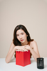 Portrait of beautiful asian woman with a red book at office desk.