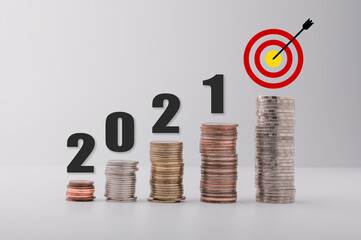 The goal of 2021 characterizes the increase in money. A pile of coins placed on a white background....