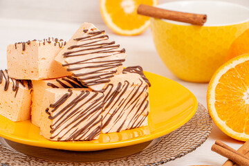 Dessert bird's milk with orange and cinnamon covered with chocolate