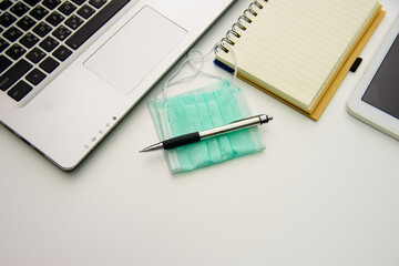 Notebook computers, pens, medical masks with notebook and smartphone