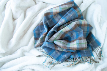 白いボアの毛布と青い格子柄のマフラーの背景