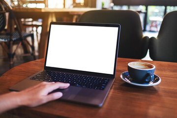 Mockup image of a woman touching on laptop computer touchpad with blank white desktop screen while drinking coffee