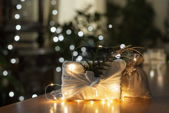 Christmas gift. Packaging in eco-friendly materials, furoshiki fabric. Bokeh, selective focus