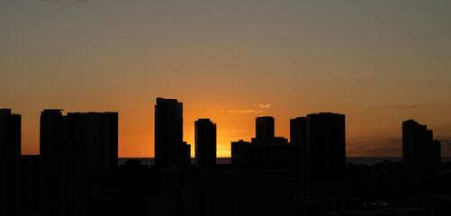 Buildings silhouetted in a tropical sunset in Honolulu Hawaii.