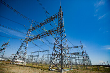 Electric transformer substation. Distribution station of electricity. Blue sky background.