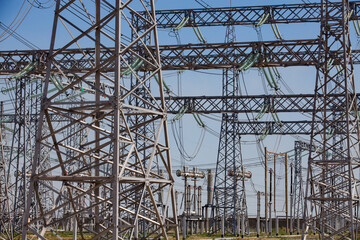 Pylons and cables. Electric transformer and Distributing substation close-up. Blue sky background.