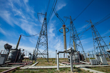Electric towers and insulators of transformer substation. Electricity Distribution station. Blue...