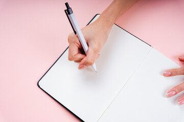 Writer using pen writing on a blank book for mock up and copy space.