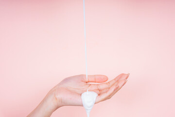 Woman hand with liquid lotion cream pouring from top screen.