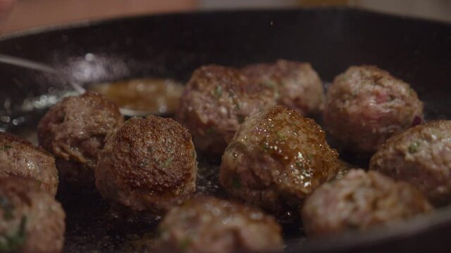 Frying meat balls in hot frying pan. Slow motion shot.