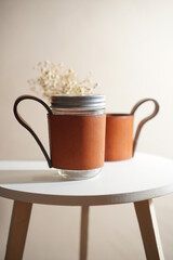 coffee mug on the white table , made from brown genuine leather