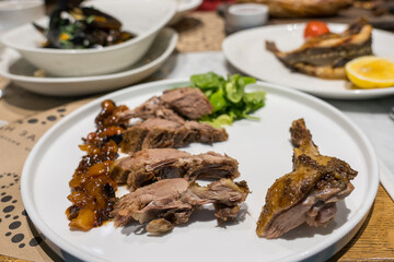 Roasted duck with fruit sauce on a white plate on the dining table