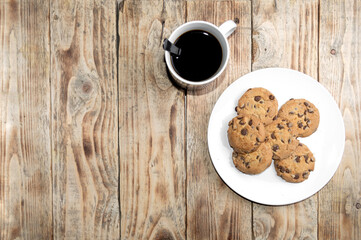 cookies in a white plate with coffee on a wooden table