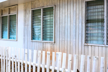 White wooden house with fence, abstract countryside architecture photo. Coastal house exterior. Romantic marine hotel with wooden fence. Simple countryside lifestyle abstraction