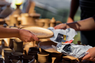Customer buying decorative ceramic plates on street market, small business, outdoor street sale in the context of the coronavirus pandemic lockdown