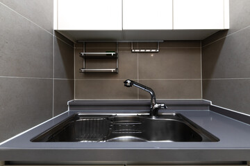 Stainless kitchen sink and tap water in the kitchen. Kitchen appliances.