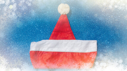 Santa Claus hat on a blue Christmas background top view. New Year concept