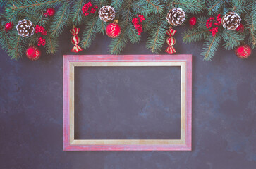 Christmas dark lilac grunge horizontal background, top view. Fir twigs, red golden berries, baubles, frame for wishes. New Year decoration, pine tree branches, snow covered cones, copy space.