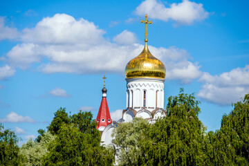 Fototapeta na wymiar The dome of the Orthodox Church surrounded by among the green trees 