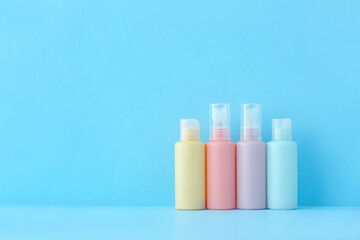 Set of travel bottles with body care cosmetics on color background