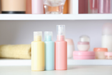 Set of travel bottles with body care cosmetics on white table