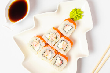 Funny edible Christmas tree made from sushi, creative idea for japanese restaurant on white background. New Year food background top view