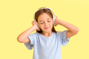 Cute little girl listing to music on color background