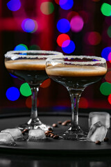 Glasses of tasty espresso martini on blurred background