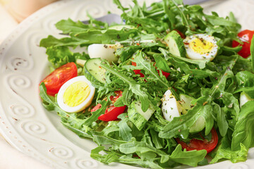 Plate with tasty arugula salad on light table