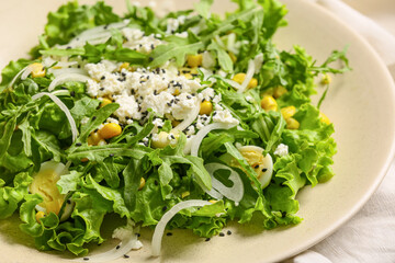 Plate with tasty arugula salad on table