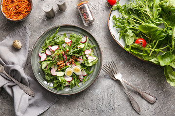 Plate with tasty arugula salad on dark background