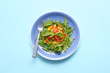 Plate with tasty arugula salad on color background