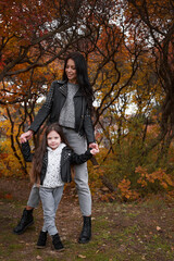 happy mother and child daughter walk in the autumn