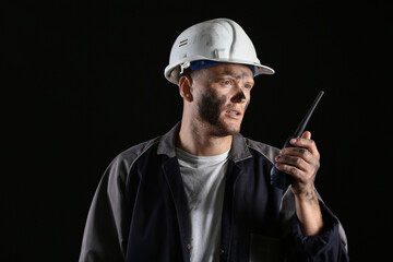 Miner man with two-way radio on dark background