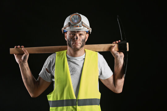 Miner man with pick axe on dark background