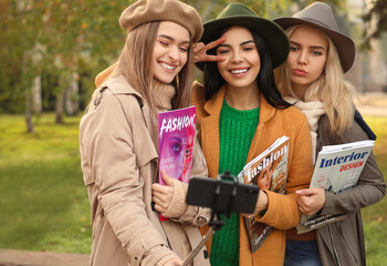 Beautiful young women taking selfie outdoors