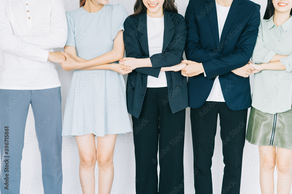 Wall mural asian young business people are holding hands to show solidarity