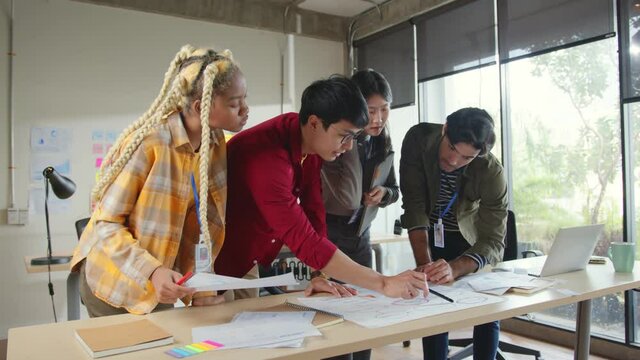 Meeting of UX developer and UI designer brainstorming about mobile app interface workflow design on table with coworker breif and color code at co-working space.Creative digital development agency.