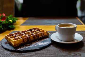Cup of coffee and Belgian waffles with chocolate