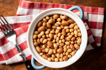 Mix of legume beans and chickpeas with sauce in pot.